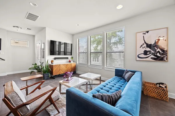 a living room with stainless steel appliances kitchen island a table and chairs in it