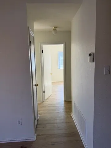 a view of a hallway with wooden floor