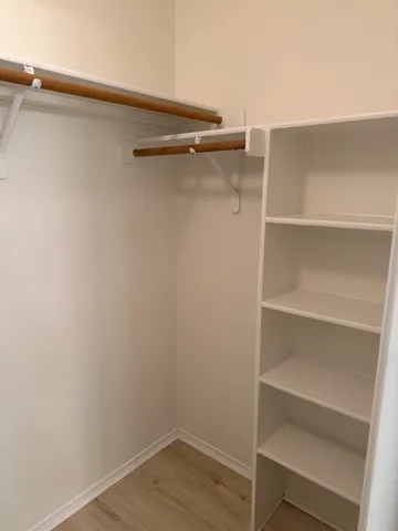 a view of walk in closet with empty racks