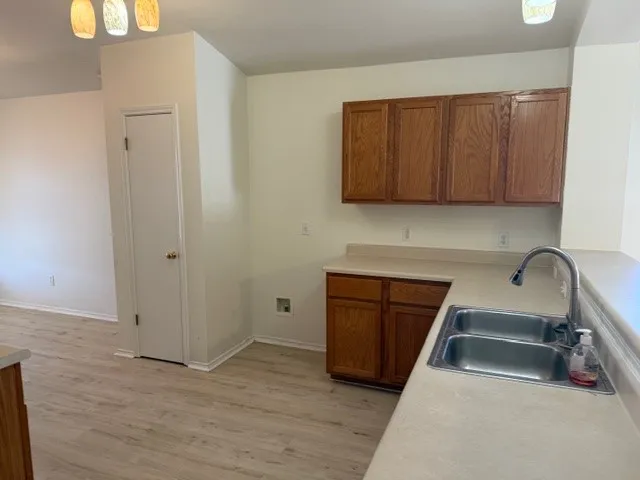 a kitchen with granite countertop a sink cabinets and wooden floor