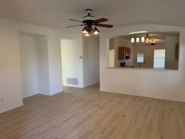 a view of a hallway with wooden floor and a chandelier