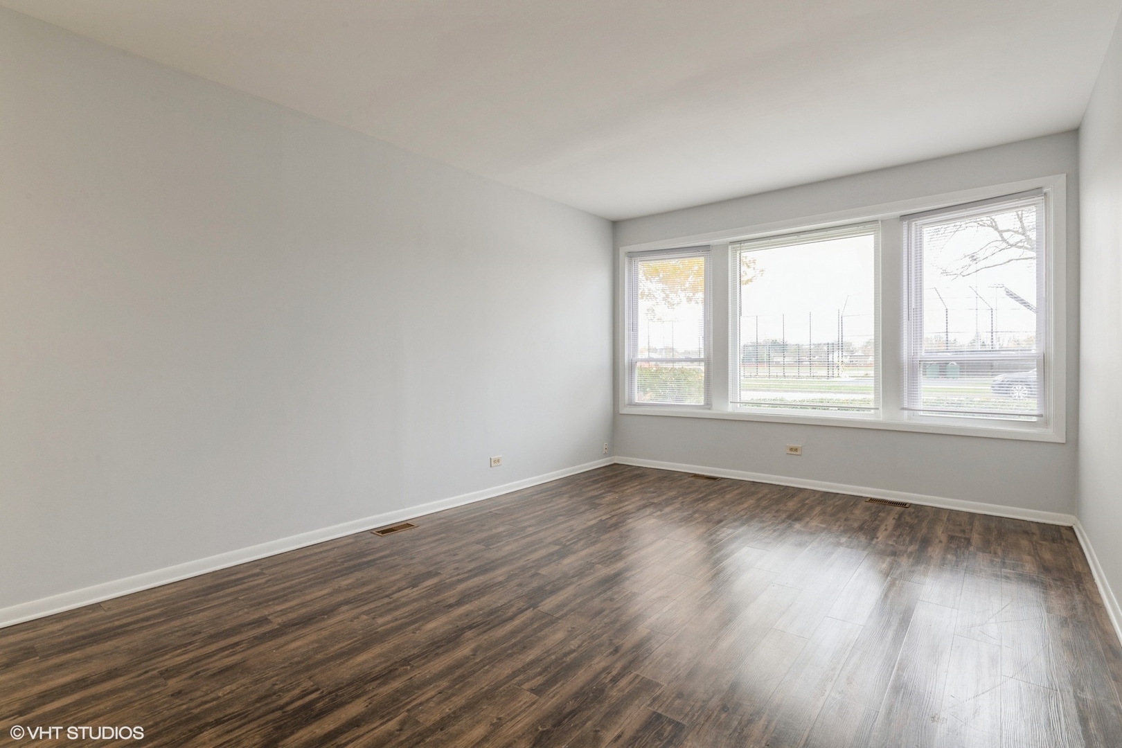 9349 Dee Road Des Plaines, IL 60016 - Photo 6 of 22 a view of an empty room with wooden floor and a window