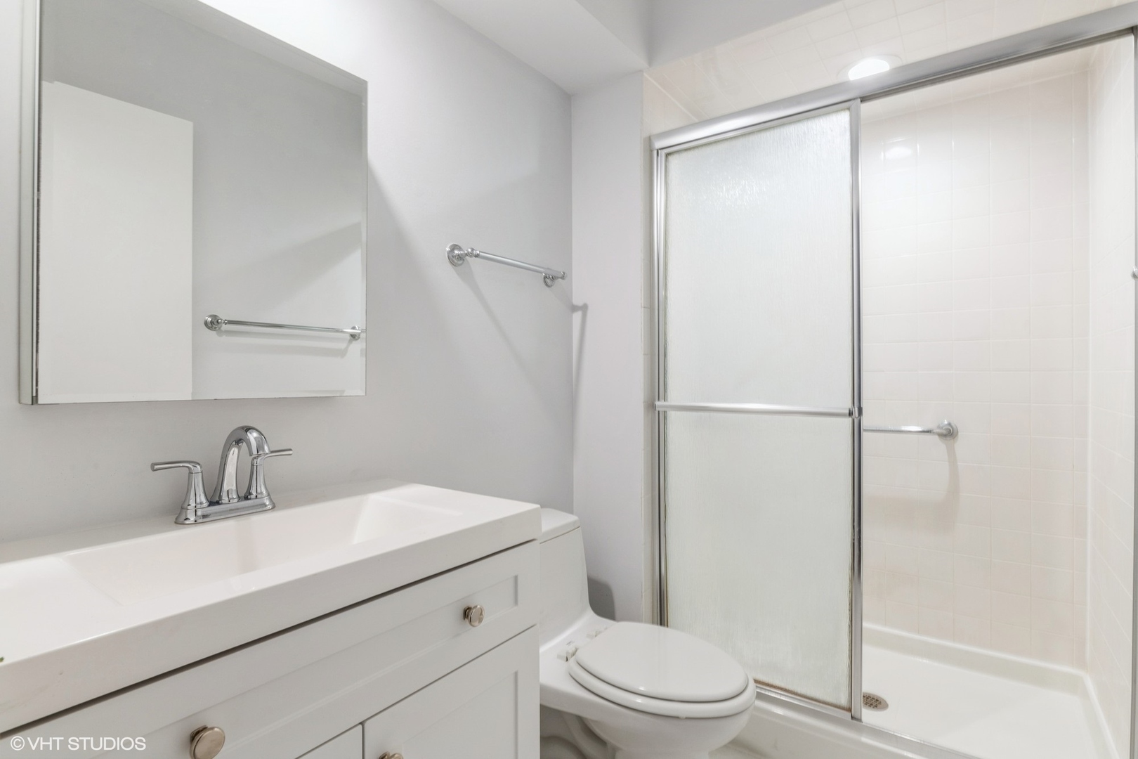 9349 Dee Road Des Plaines, IL 60016 - Photo 10 of 22 a bathroom with a sink a mirror a toilet and shower