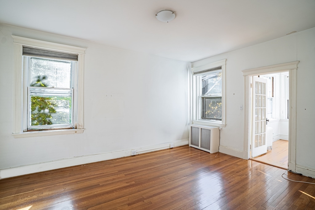 12 Gibbs Street, Unit 2 Brookline, MA 02446 - Photo 13 of 21 an empty room with wooden floor and windows