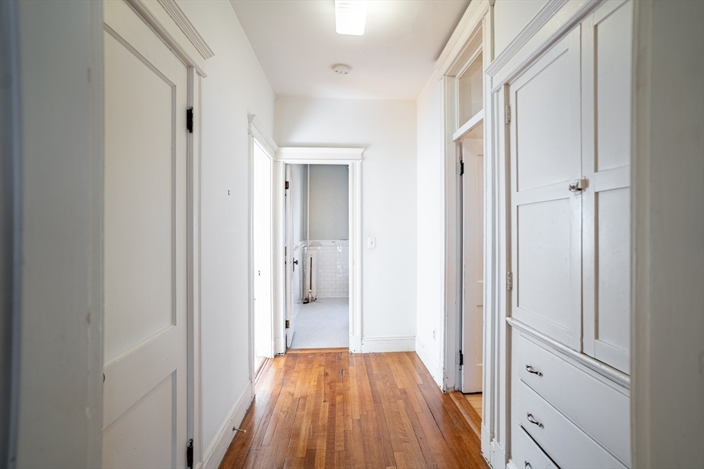 12 Gibbs Street, Unit 2 Brookline, MA 02446 - Photo 16 of 21 a view of a hallway with wooden floor and a bathroom