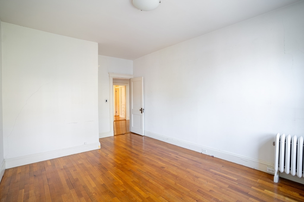 12 Gibbs Street, Unit 2 Brookline, MA 02446 - Photo 18 of 21 a view of an empty room with wooden floor