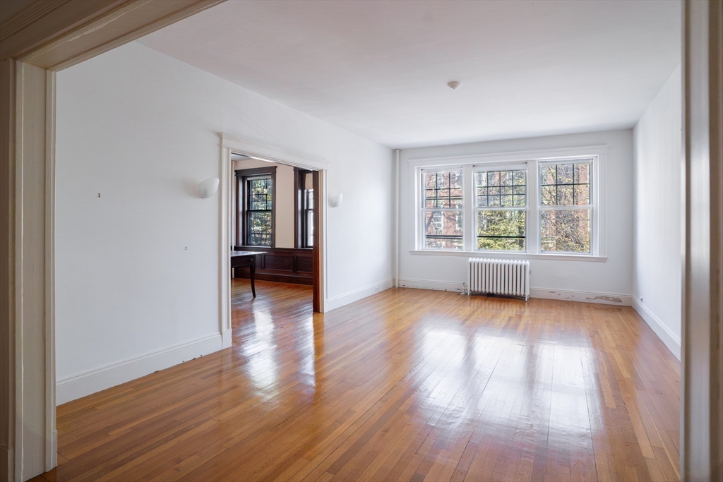 12 Gibbs Street, Unit 2 Brookline, MA 02446 - Photo 2 of 21 an empty room with wooden floor and windows