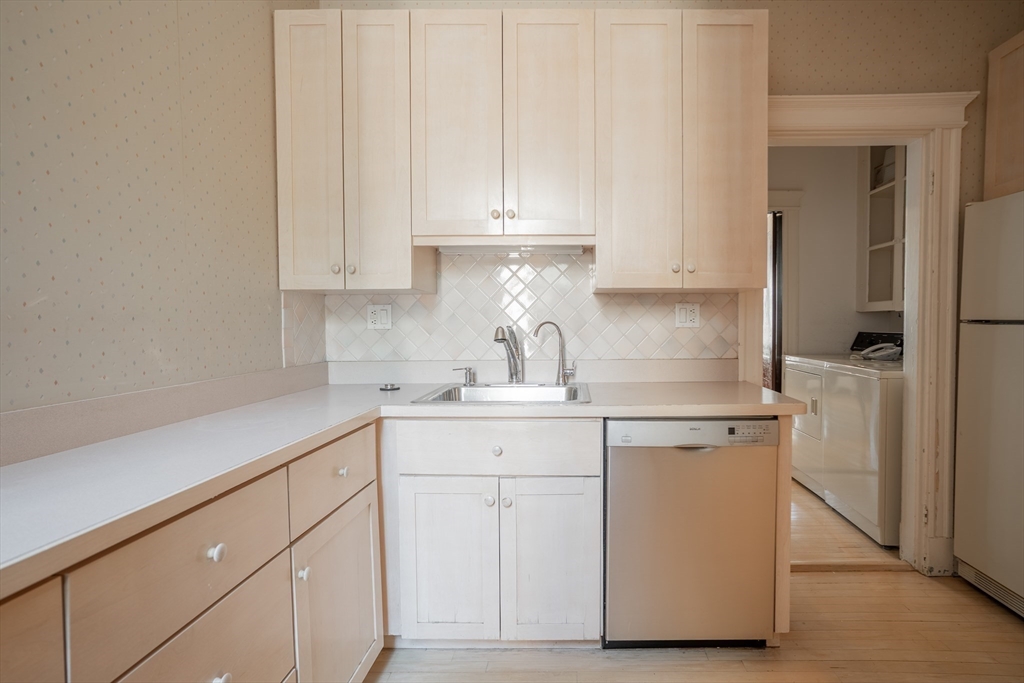 12 Gibbs Street, Unit 2 Brookline, MA 02446 - Photo 9 of 21 a kitchen with white cabinets and sink