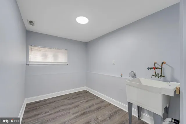 a room with a window wooden floor and a sink