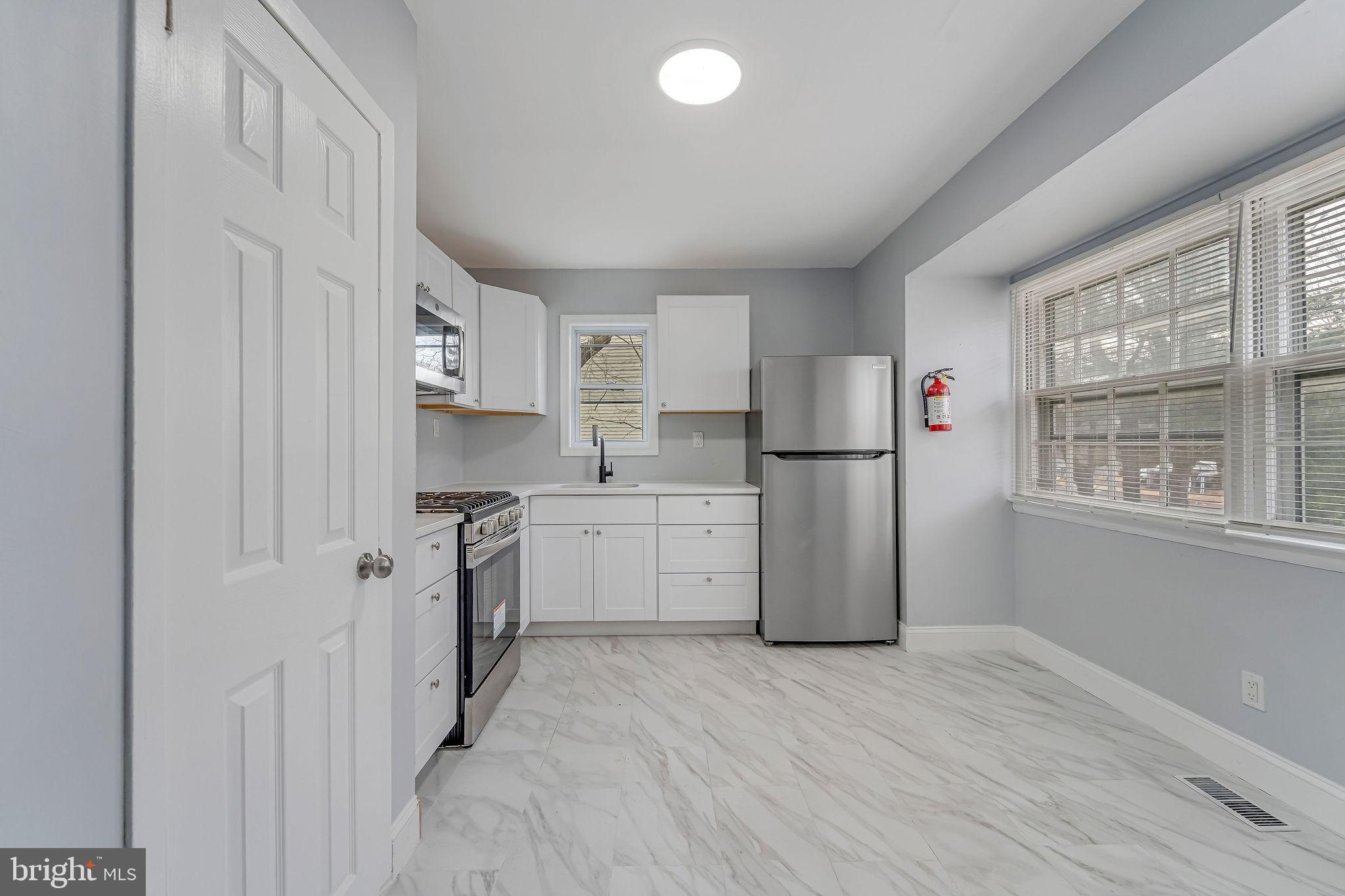 2405 North Cuthbert Drive Lindenwold, NJ 08021 - Photo 6 of 31 a kitchen with a refrigerator a stove top oven and white cabinets