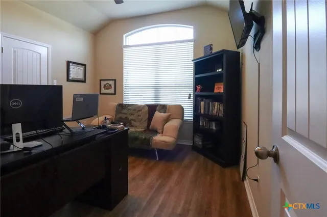 a view of a hallway to a livingroom with furniture and windows