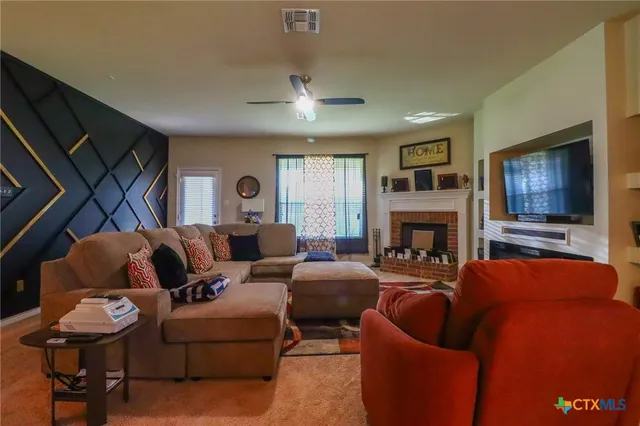 a living room with furniture a flat screen tv and a fireplace