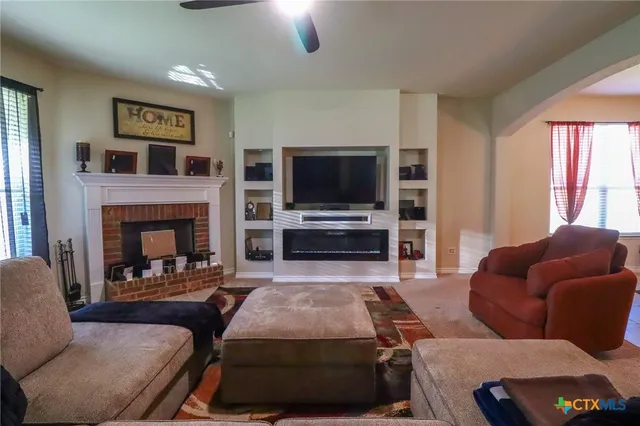 a living room with furniture and a ceiling fan