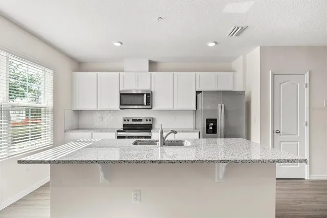 a kitchen with a sink cabinets and wooden floor