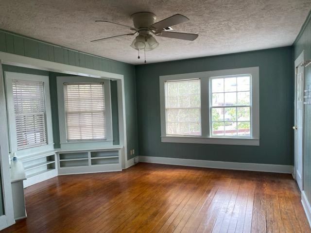 1004 Mccall Avenue Conroe, TX 77301 - Photo 6 of 14 an empty room with wooden floor and windows