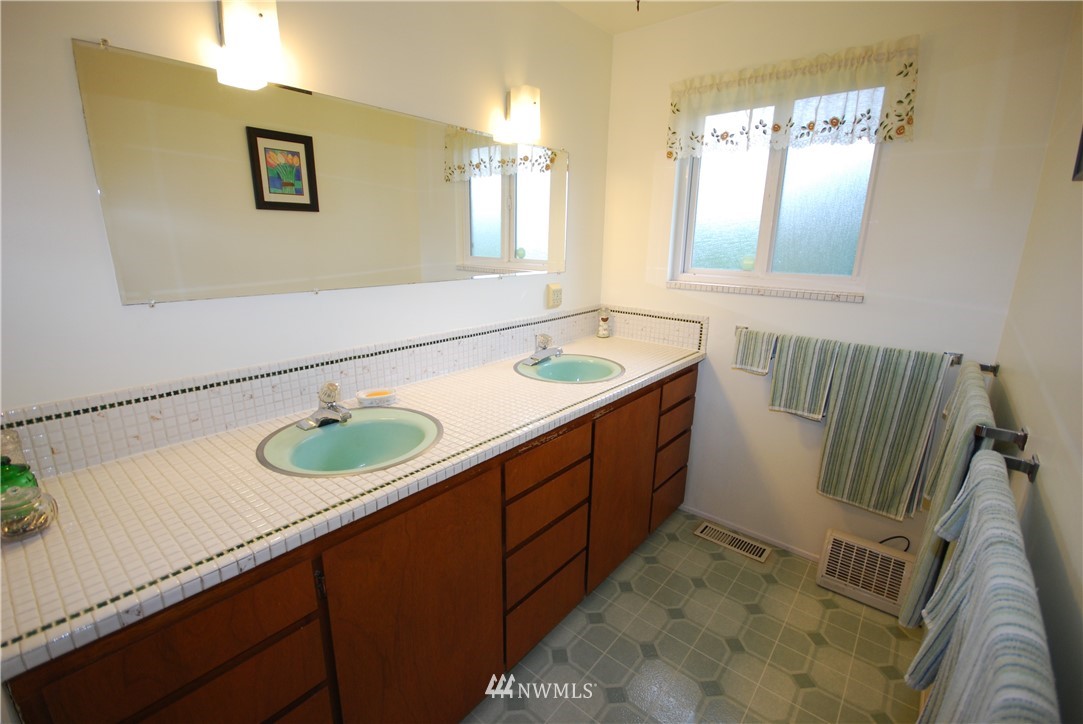 10404 Southeast 166th Street Renton, WA 98055 - Photo 16 of 29 a bathroom with a double vanity sink and a mirror