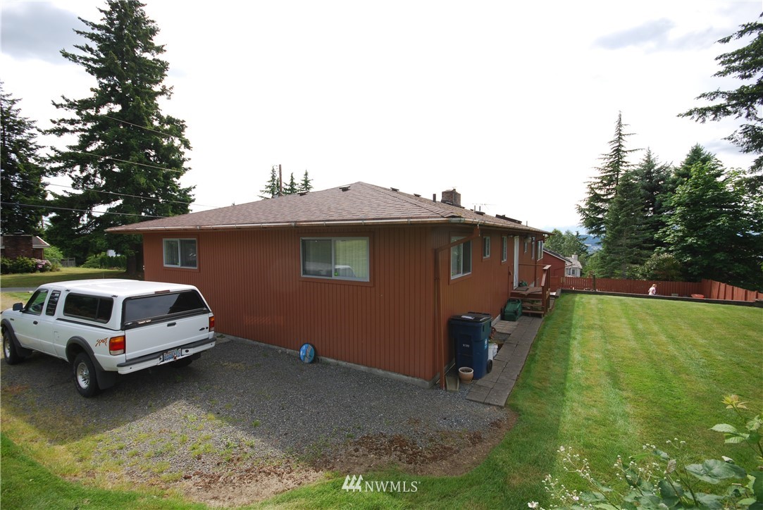 10404 Southeast 166th Street Renton, WA 98055 - Photo 3 of 29 a white house covered with tall trees