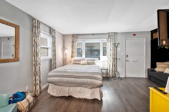 a bedroom with a bed and wooden floor