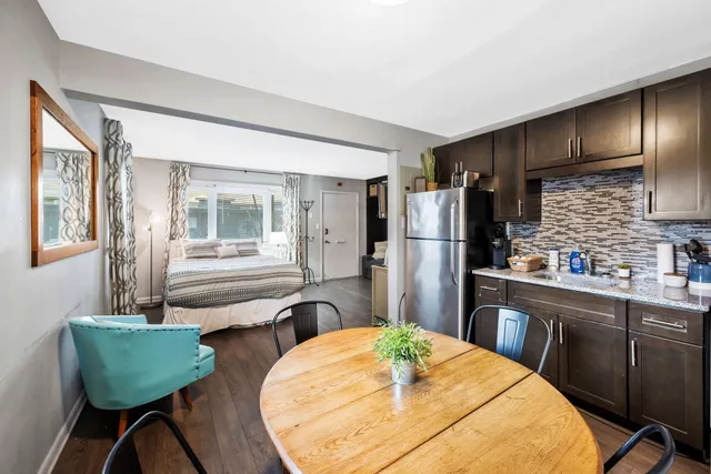 a kitchen with stainless steel appliances kitchen island granite countertop a refrigerator a stove a sink dishwasher with a dining table and chairs