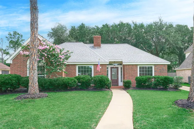 a front view of a house with a yard and trees