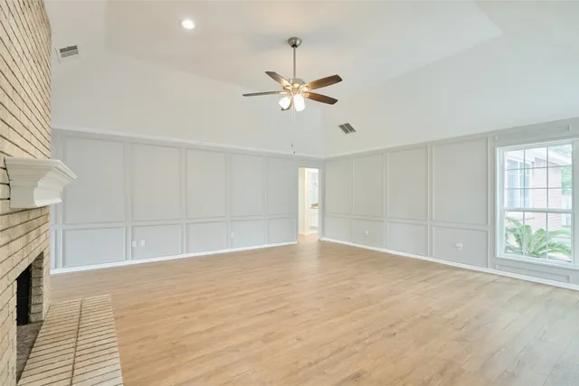 an empty room with wooden floor and fireplace