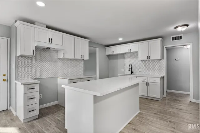a kitchen with a stove sink and cabinets
