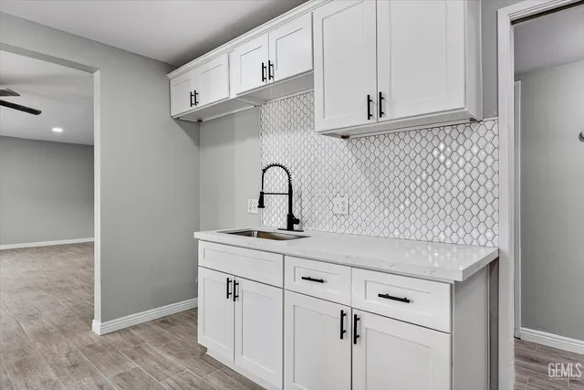 a kitchen with stainless steel appliances granite countertop a sink and a white cabinets