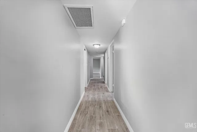 a view of a hallway with wooden floor