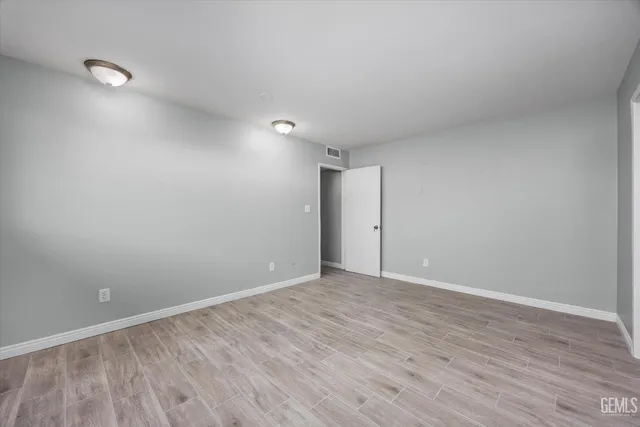 a view of an empty room with wooden floor