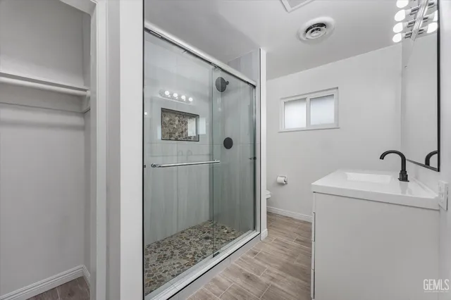 a bathroom with a sink a toilet and shower