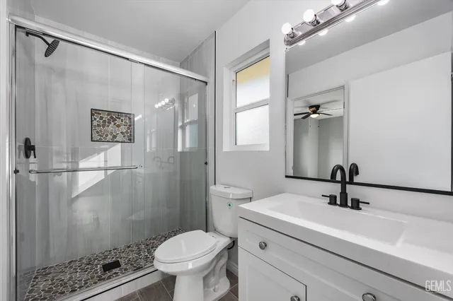 a bathroom with a sink a toilet a shower and a mirror