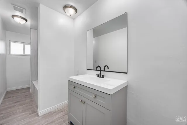 a bathroom with a sink a mirror and vanity