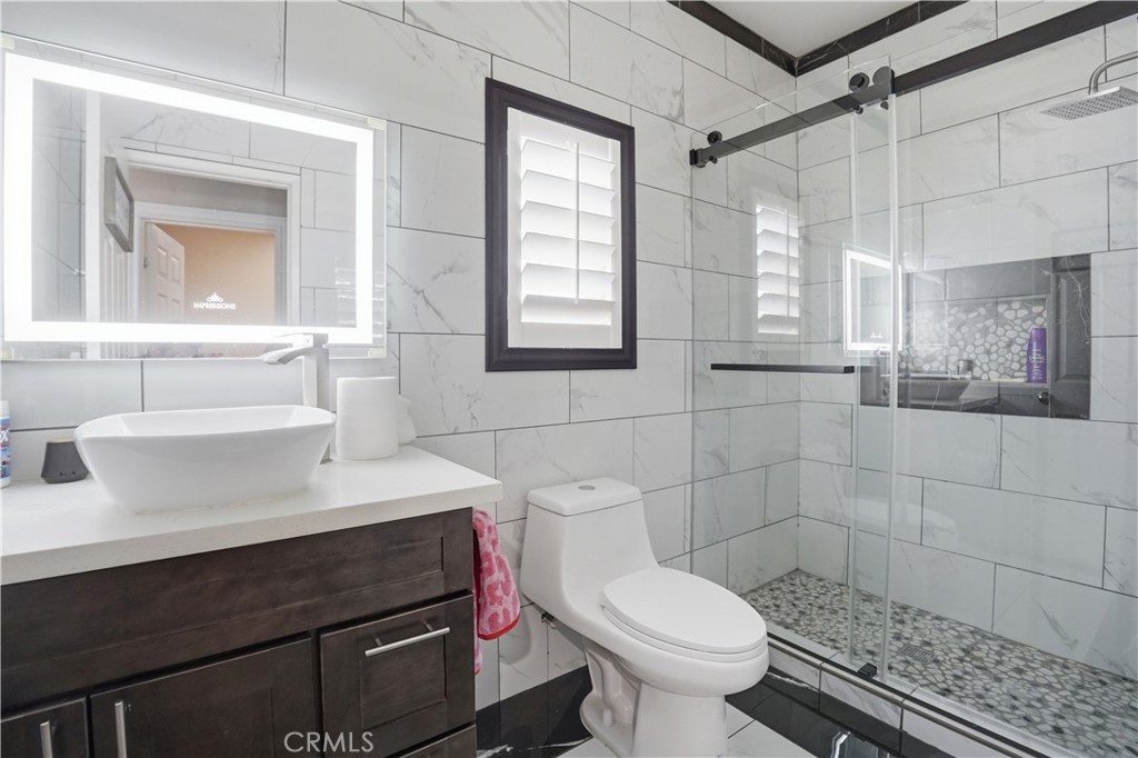 4415 Bethel Road Jurupa Valley, CA 92509 - Photo 33 of 65 a bathroom with a sink toilet a mirror and shower