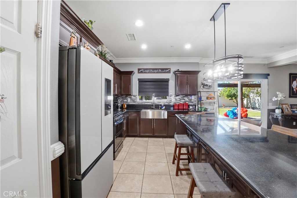 4415 Bethel Road Jurupa Valley, CA 92509 - Photo 45 of 65 a kitchen with stainless steel appliances granite countertop a refrigerator a sink dishwasher a oven and a dining table with wooden floor