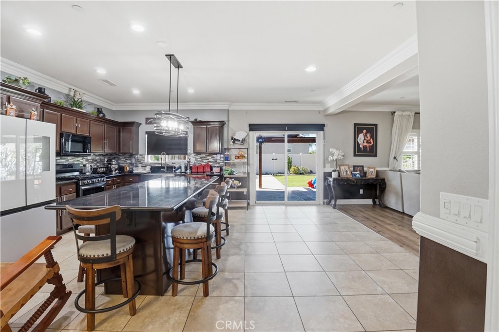 4415 Bethel Road Jurupa Valley, CA 92509 - Photo 59 of 65 a kitchen with stainless steel appliances granite countertop a sink a stove a refrigerator cabinets and chairs