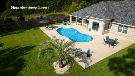 an aerial view of a house with swimming pool garden and patio