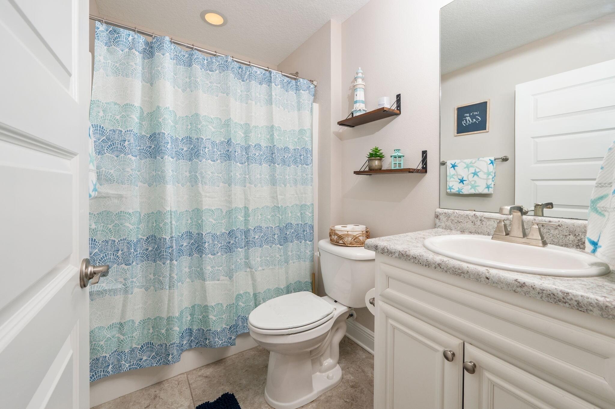2714 Ola Broxson Road Navarre, FL 32566 - Photo 43 of 52 a bathroom with a granite countertop sink a toilet and a shower
