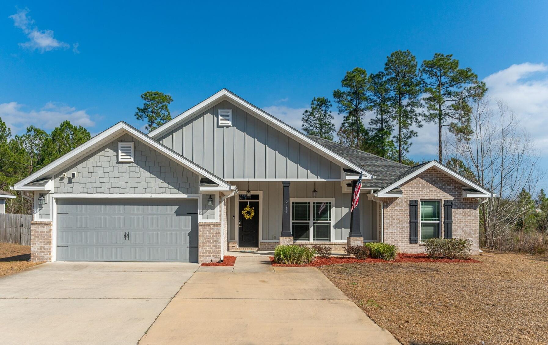 2714 Ola Broxson Road Navarre, FL 32566 - Photo 6 of 52 a front view of a house with a yard and garage