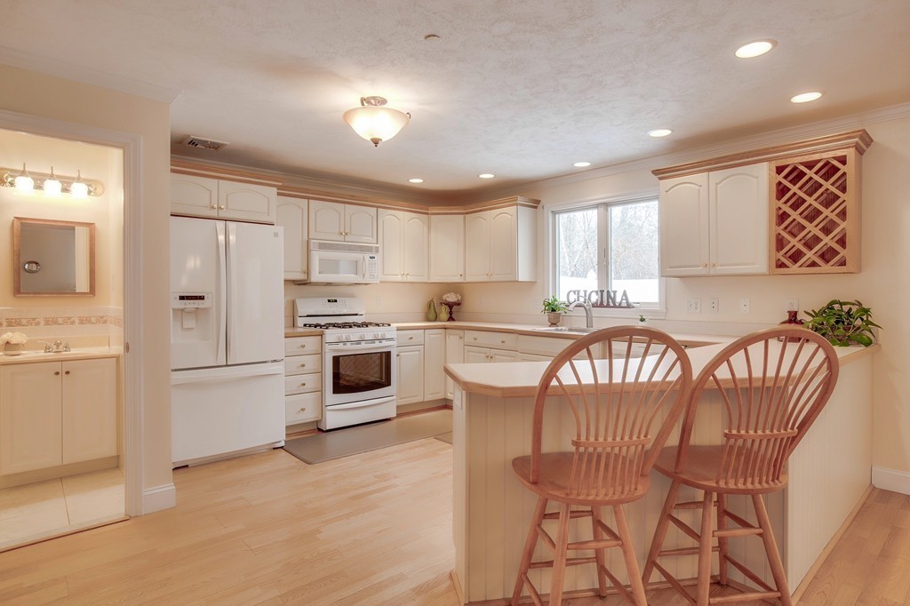 216 Rangeway Road, Unit 192 Billerica, MA 01862 - Photo 10 of 20 a kitchen with stainless steel appliances granite countertop a stove a sink a refrigerator with a dining table and chairs
