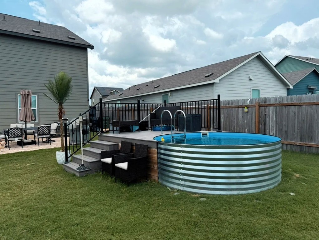 View of swimming pool with a patio area and a fenced backyard