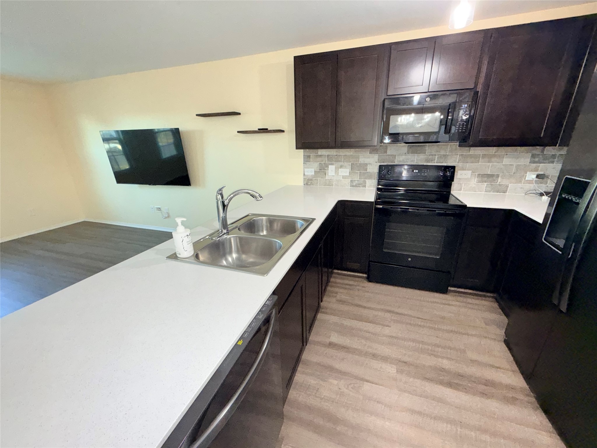228 Texas Angel Way Jarrell, TX 76537 - Photo 24 of 33 a kitchen with kitchen island granite countertop a sink and a stove top oven with wooden floor