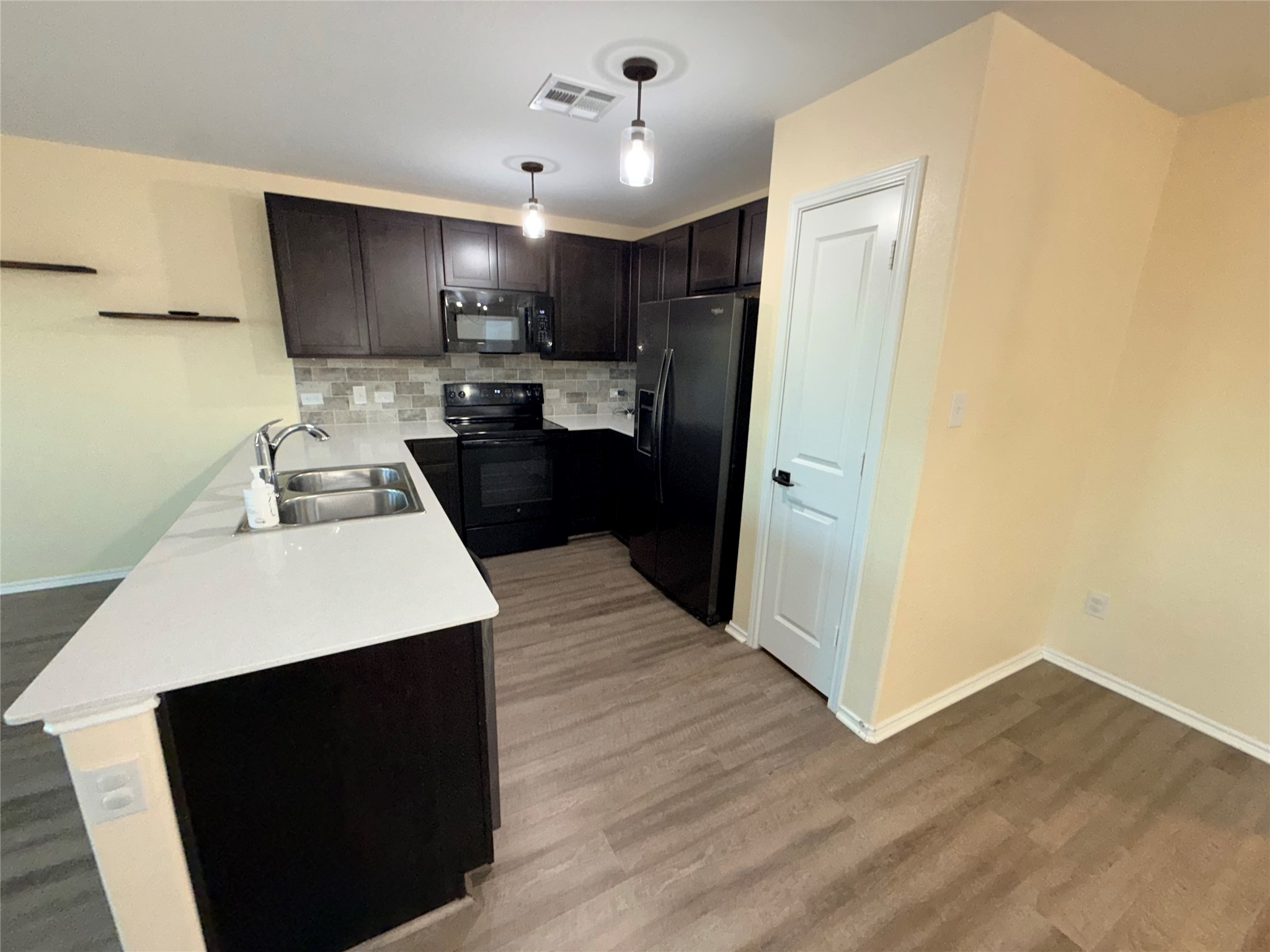 228 Texas Angel Way Jarrell, TX 76537 - Photo 5 of 33 a kitchen with a sink a refrigerator and cabinets