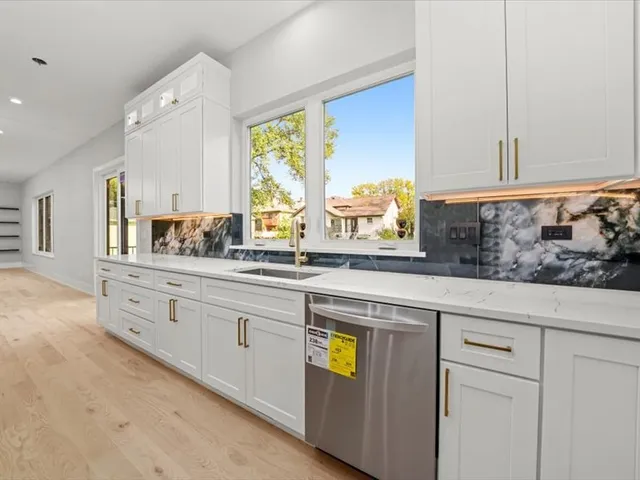 a kitchen with stainless steel appliances white cabinets and a window