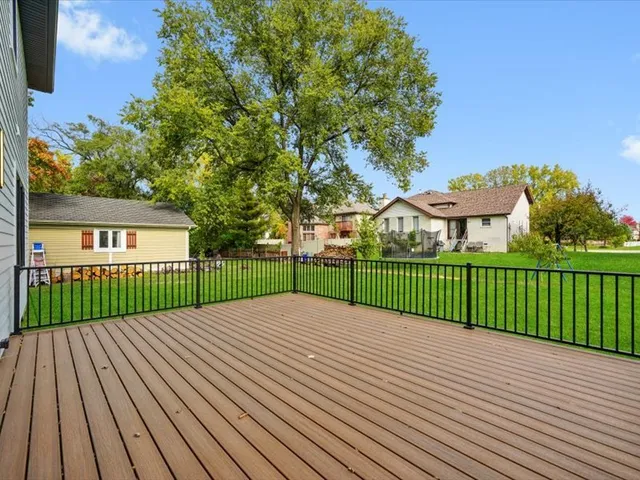 a view of a deck and a yard with green space