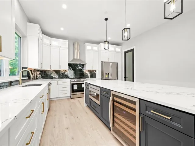 a kitchen with stainless steel appliances granite countertop a sink a stove and a refrigerator