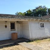 a view of a wooden house and a yard