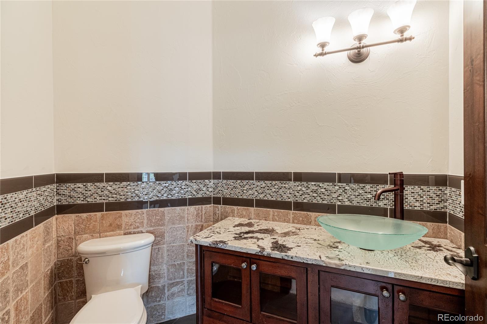 26050 Henderson Park Road Oak Creek, CO 80467 - Photo 18 of 40 a bathroom with a granite countertop sink and a toilet