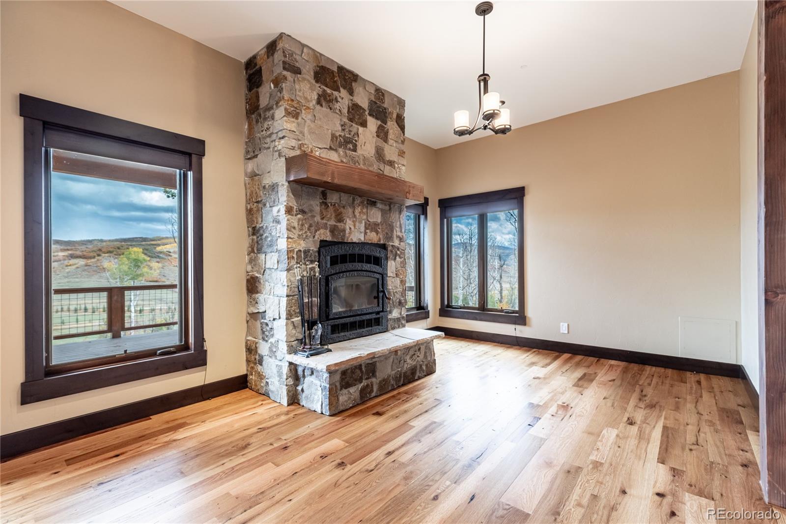 26050 Henderson Park Road Oak Creek, CO 80467 - Photo 9 of 40 a view of an empty room with wooden floor fireplace and a window