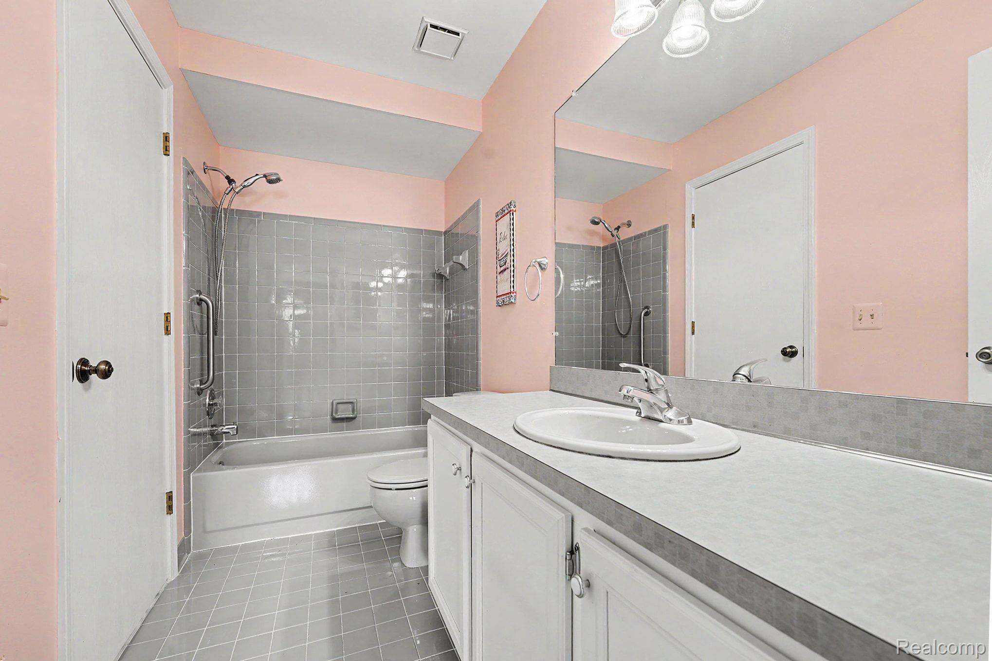 42619 Cedar Ridge Drive Clinton Township, MI 48038 - Photo 9 of 18 Bathroom with a built-in tub and shower combination featuring gray tile surround