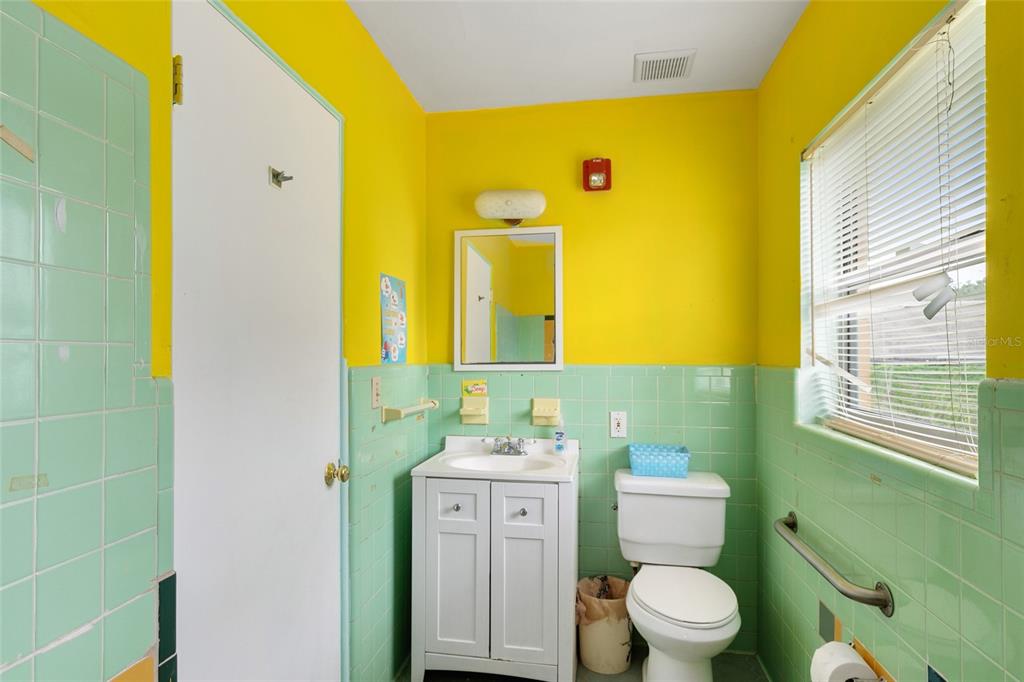 4607 North Pine Hills Road Orlando, FL 32808 - Photo 12 of 26 a bathroom with a toilet sink and mirror